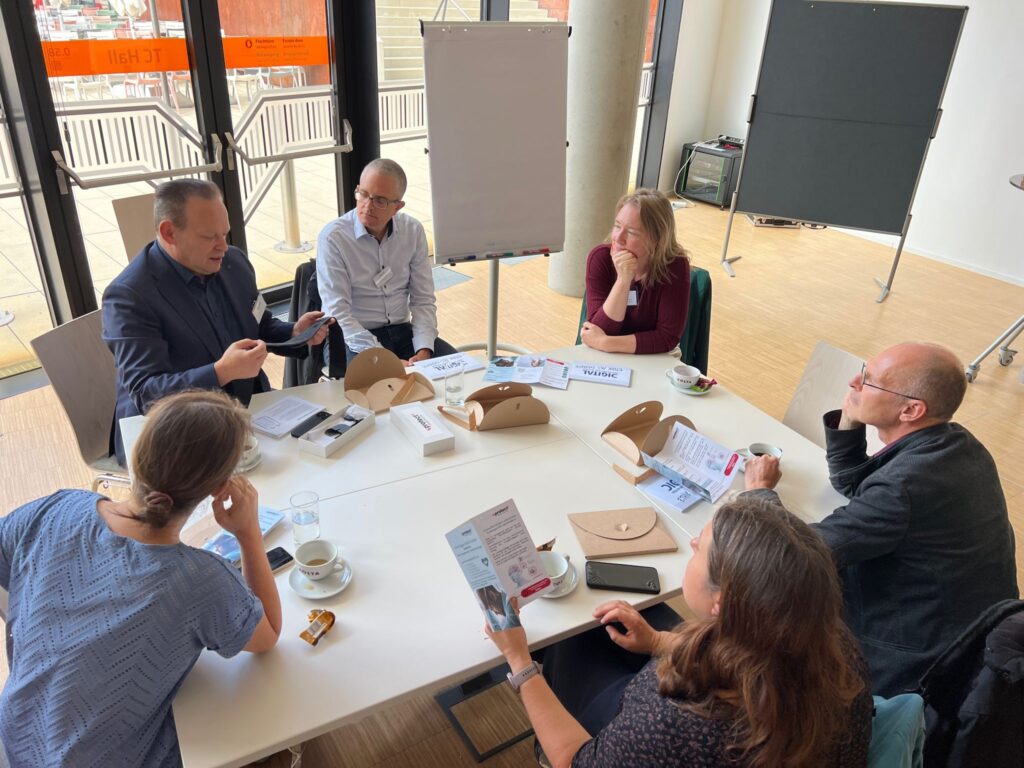 Workshopsituation: 6 Personen rund um einen Tisch mit dem Kartenset Ethik als Chance und Günther Graber, welcher ein smartess Medizinprodukt präsentiert